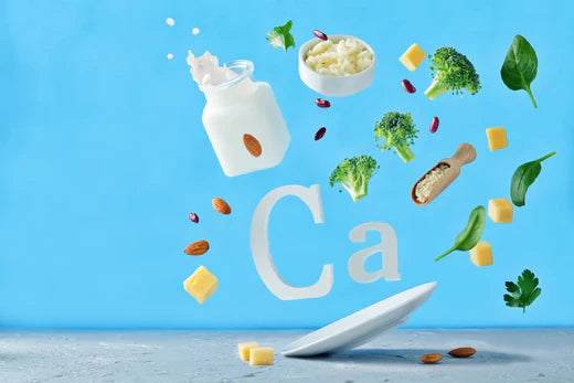 Calcium-rich foods such as milk, cheese, and broccoli floating on blue background.