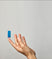Hand holding a blue fatty15 C15 supplement against a neutral background.
