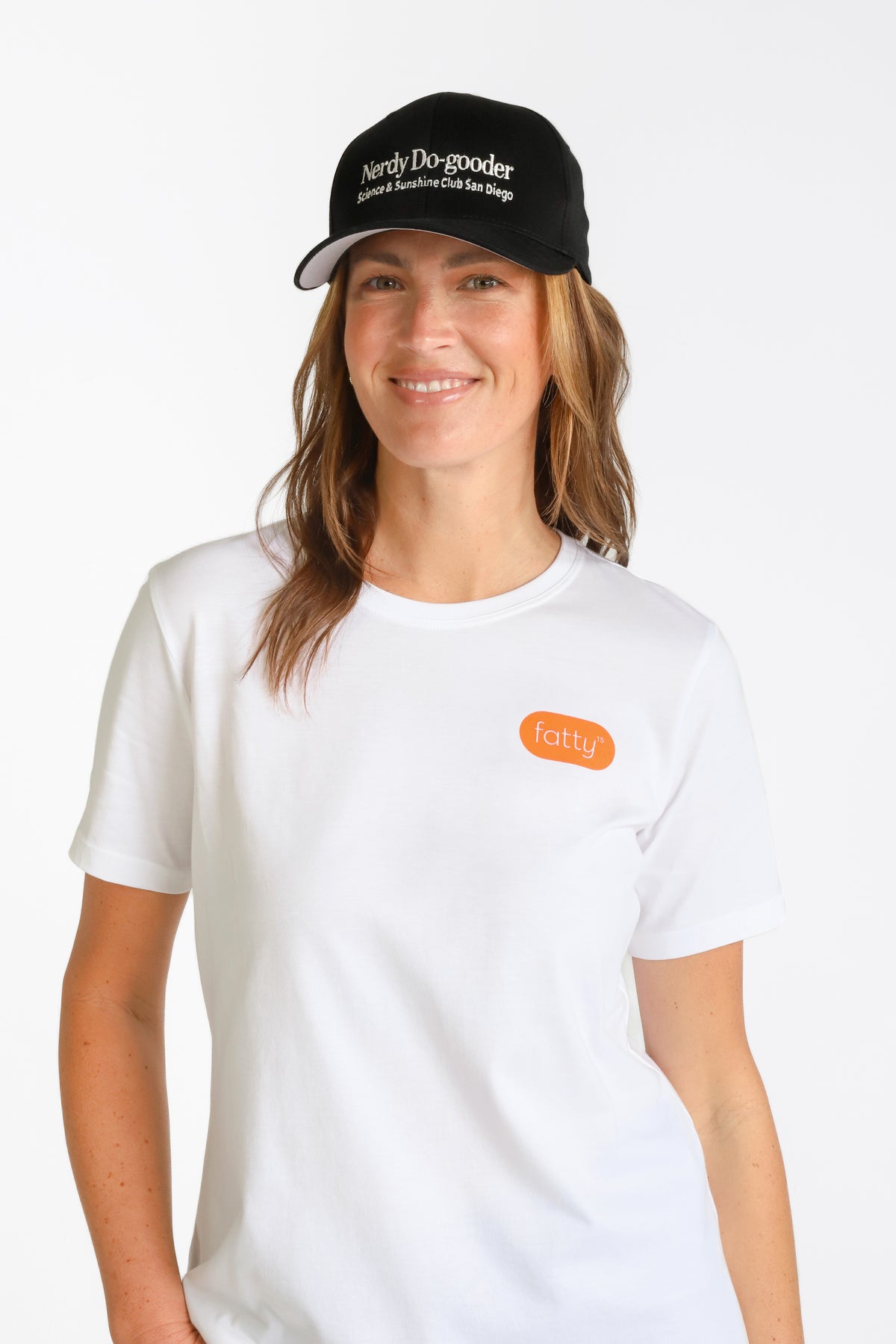 
                Woman wearing a black cap and white t-shirt with Fatty15 logo.