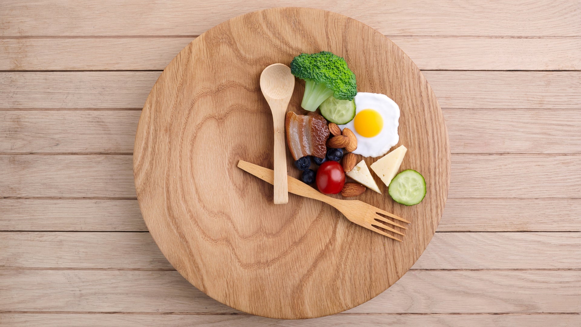 Diet-friendly small portion of diverse healthy foods on a wooden plate.