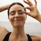 Woman smiling with a sense of well-being near the ocean.
