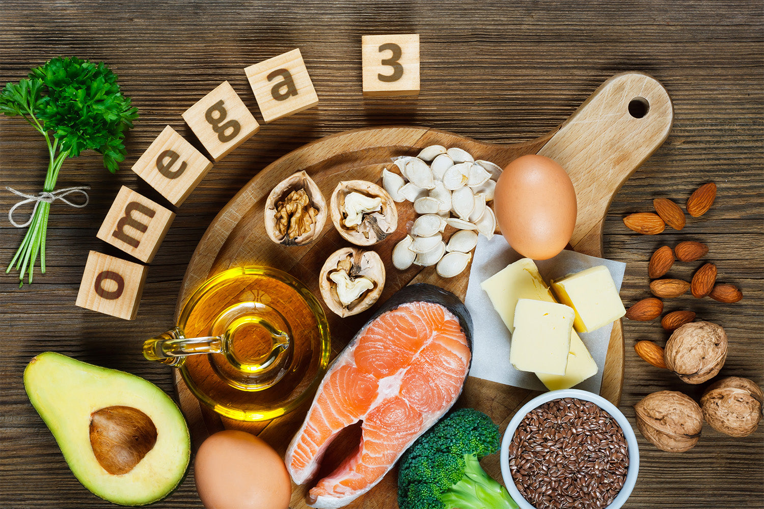Foods rich in Omega-3, including salmon, nuts, and oil, on a wooden board.