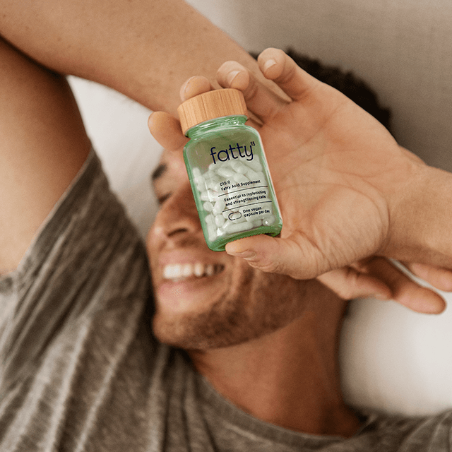 
                Smiling person holding Fatty15&#39;s C15 supplement bottle.